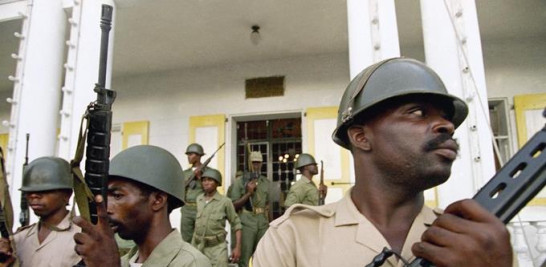 Soldados haitianos montan guardia frente al cuartel militar en Port-au-Prince, Haití, el 18 de septiembre de 1994. El primer ministro de Haití, Ariel Henry, y 18 funcionarios de alto rango solicitaron en la segunda semana de octubre de 2022, el despliegue inmediato de tropas extranjeras. Tropas armadas como bandas y manifestantes paralizan el país. (Foto AP/John McConnico, archivo)