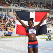 Marysabel Senyú posando con la bandera tricolor, luego de obtener la quinta medalla dorada para el atletismo.