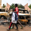 Niños pasan frente a los autos quemados frente a la sede del Partido Níger para la Democracia y el Socialismo del presidente Bazoum en Niamey.