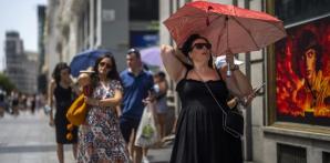 Una mujer sostiene un paraguas para protegerse del sol durante un caluroso día soleado en Madrid, España, el 18 de julio de 2022. Mirando hacia atrás al clima de 2022 con meses de análisis, la Organización Meteorológica Mundial dice que el año pasado realmente fue tan malo como parecía.