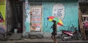 Una chica camina bajo la lluvia en Haití.