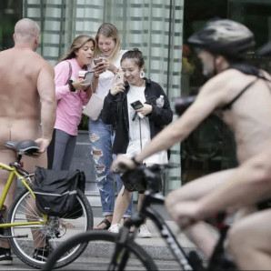 Un ciclista desnudo posa para las fotos mientras otros participantes pasan en bicicleta durante el paseo en bicicleta desnudo de Filadelfia en Filadelfia, el 8 de septiembre de 2018