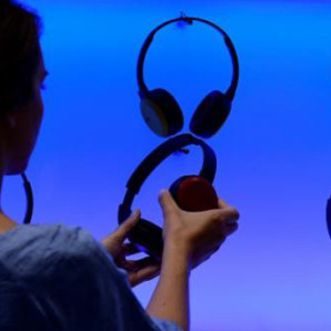 Una mujer posa en una instalacion de auriculares en una feria en Berlín.