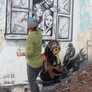 El artista callejero yemení Alaa Rubil termina una de sus obras de arte pintadas en una pared en la ciudad portuaria sureña de Adén. Rubil usa los edificios llenos de proyectiles de su ciudad natal como lienzo, pintando imágenes de muerte y desesperación para arrojar luz sobre los horrores y las víctimas de la guerra.