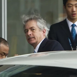 El director de la CIA, William Burns, centro, sube a un auto al arribar al Aeropuerto Internacional de la Capital, Beijing, 1 de mayo de 2012.