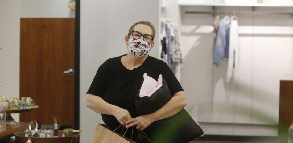 En esta fotografía del miércoles 13 de mayo de 2020, Monique Kursar habla sobre comprar en la tienda Velvet Window de Dallas. (AP Foto/LM Otero)