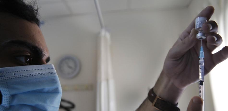Un trabajador de la salud llena una jeringa con la vacuna contra el coronavirus COVID-19.