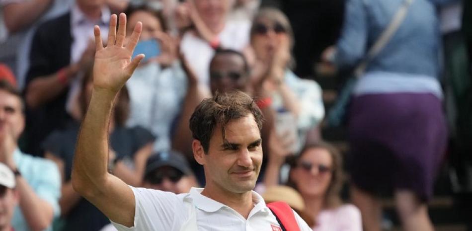 Roger Federer saluda al público luego de completar su victoria sobre Richard Gasquet en el Abierto de Wimbledon.