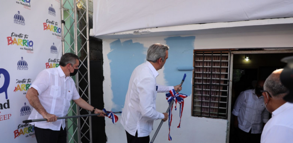 El presidente Luis Abinader cuando daba los primeros toques a la pintura de la vivienda.