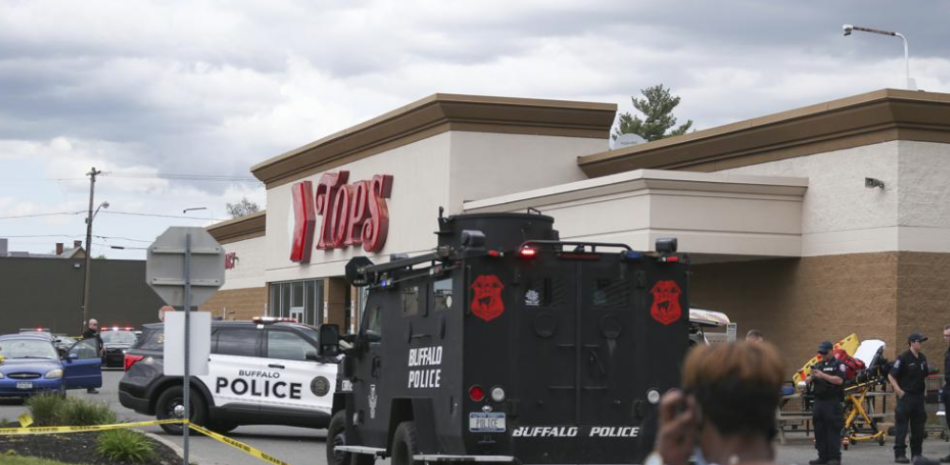 Una multitud se congrega cuando la policía investiga un tiroteo en un supermercado, el sábado 14 de mayo de 2022, en Buffalo, Nueva York. (AP Foto/Joshua Bessex)