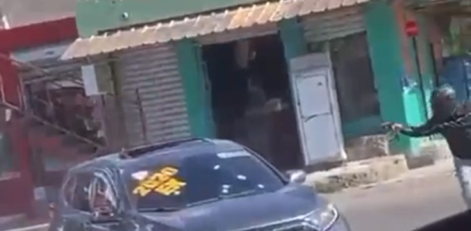 Un encapuchado descarga una pistola-ametralladora contra una yipeta, matando a 2 de sus tres ocupantes . TOMADA DE VIDEO