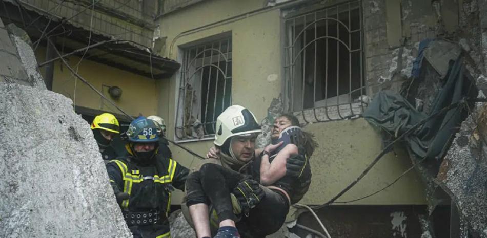 Un bombero carga a una mujer herida, retirada de entre los escombros de un edificio tras un ataque ruso el sábado en Dnipro, Ucrania, el domingo 15 de enero de 2023. AP
