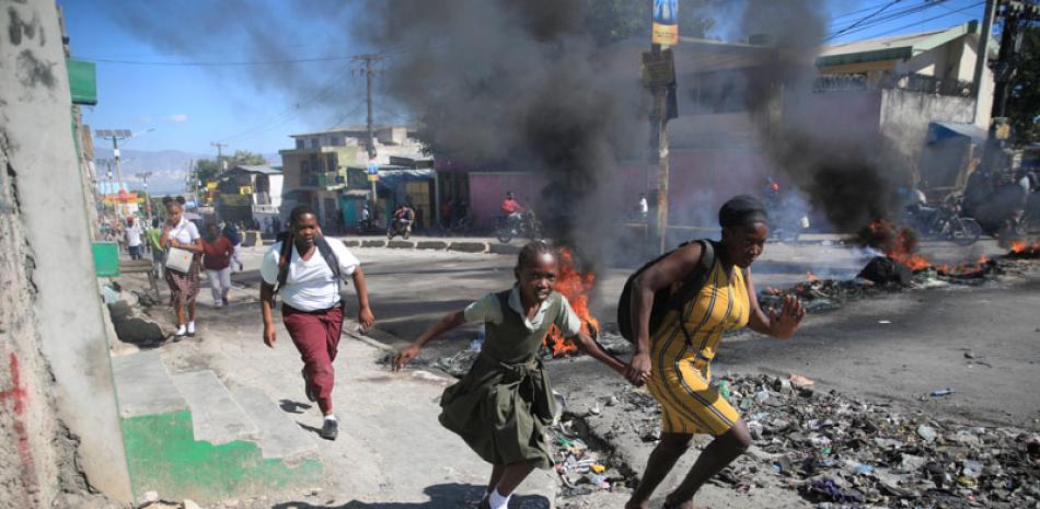 Policías descontentos se manifestaron ayer en la capital haitiana, Puerto Príncipe, bloqueando carreteras, quemando neumáticos y disparando armas de fuego al aire, para protestar por los asesinatos de colegas a manos de pandillas. AFP