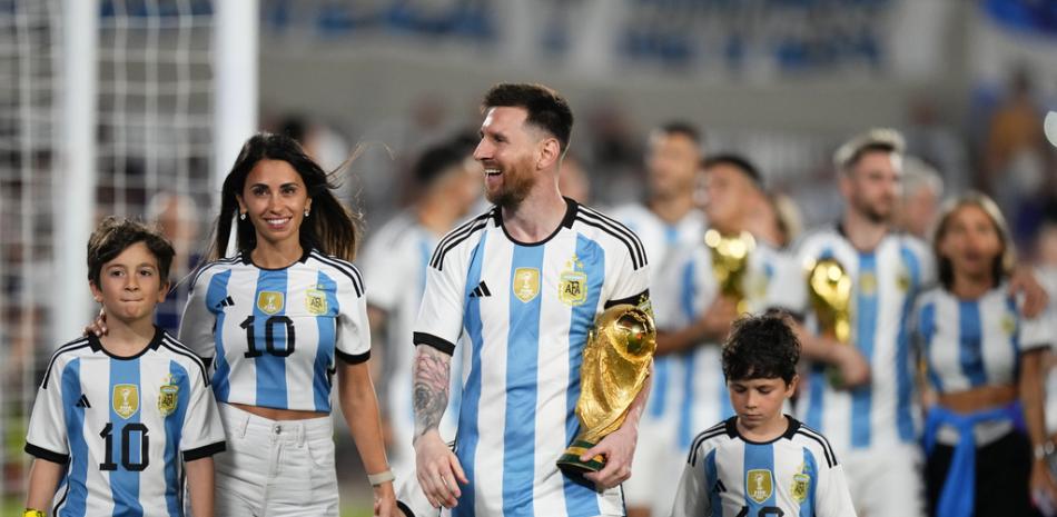 Lionel Messi de Argentina camina con la réplica del equipo ganador del trofeo de la Copa Mundial de la FIFA, acompañado por su Antonela Roccuzzo y sus hijos. (Foto AP/Natacha Pisarenko)
