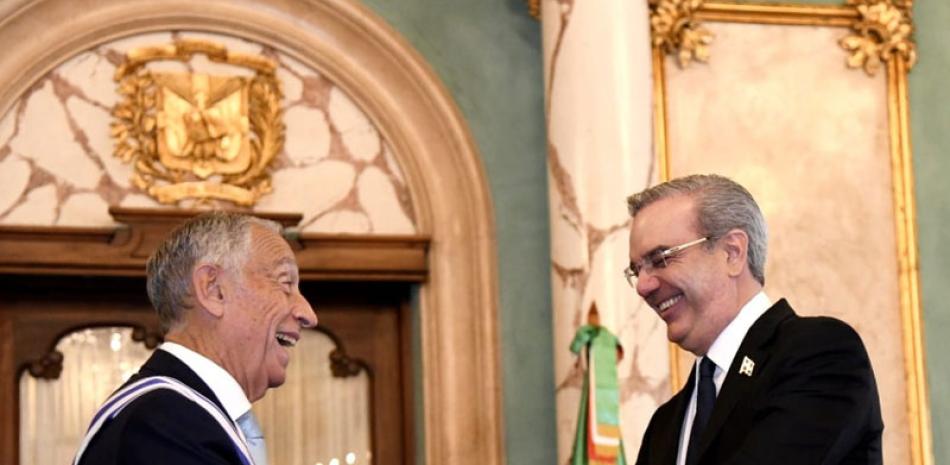 El presidente   Abinader  y el mandatario de  Portugal, Marcelo Rebelo, sonrientes, se saludan con un apreton de manos.
