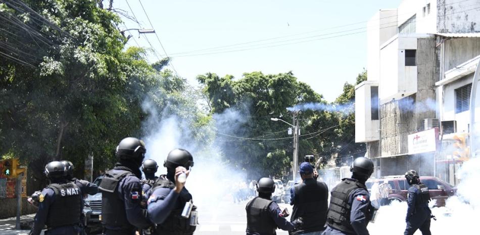 Agentes SWAT de la Policía Nacional lanzando bombas lacrimógenas a decenas de militantes del PLD. Foto: Víctor Ramírez/LD.