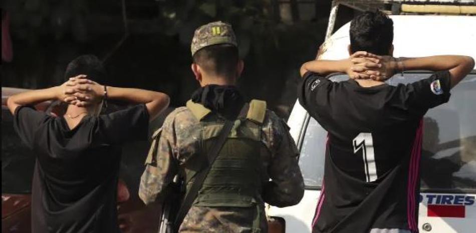Un soldado verifica la identificación de los jóvenes en la calle principal del barrio La Campanera en Soyapango, El Salvador, el domingo 5 de marzo de 2023. (Foto AP/Salvador Meléndez)