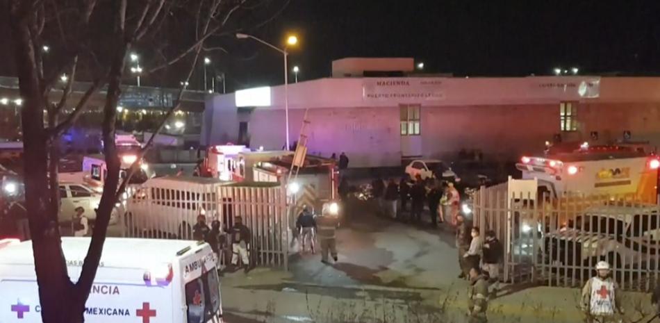 Esta imagen extraída de un video muestra ambulancias y equipos de emergencias ante un centro migratorio en Ciudad Juárez, México, el martes 28 de marzo de 2023. AP