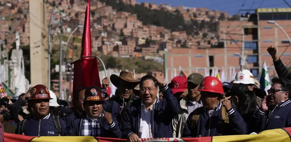 El presidente boliviano Luis Arce, en el centro, grita consignas durante la marcha del Día del Trabajo en La Paz, ayer. El segundo desde la izquierda es Juan Carlos Huarachi, líder del principal sindicato del país.