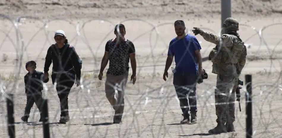Migrantes esperan a las autoridades estadounidenses en la frontera entre EEUU y México, visto desde Ciudad Juárez, México, el miércoles 10 de mayo de 2023