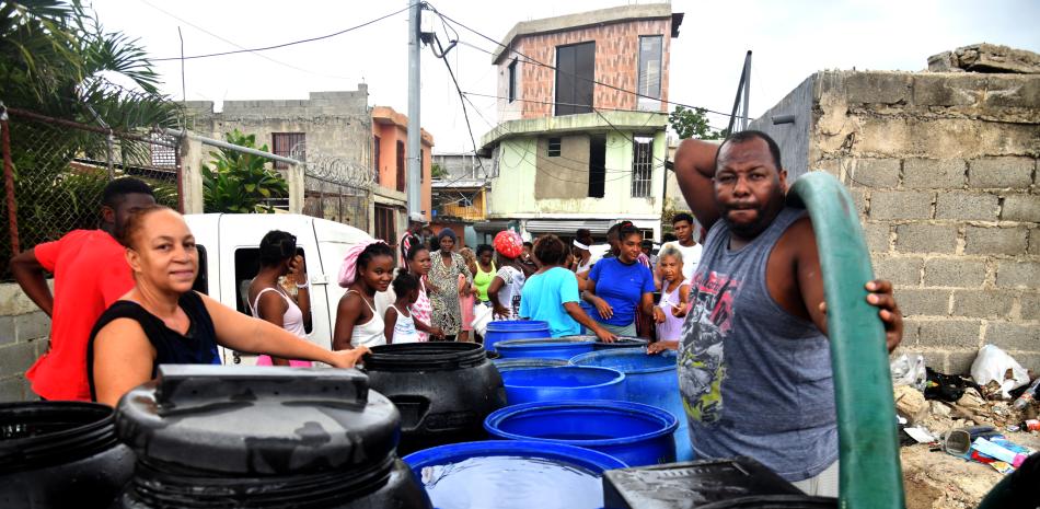 Comunitarios hacen filas para coger agua ante la escasez de la misma.