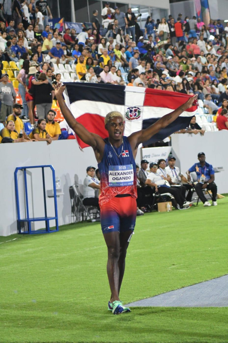 Alexander Ogando celebra con la bandera dominicana tras ganar la medalla de oro en los 200 metros planos.