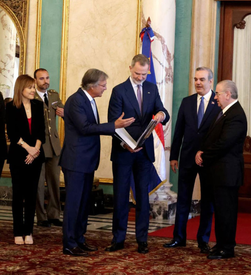 El Rey de España al recibir una copia de la obra de manos del embajador Antonio Pérez Hernández.
