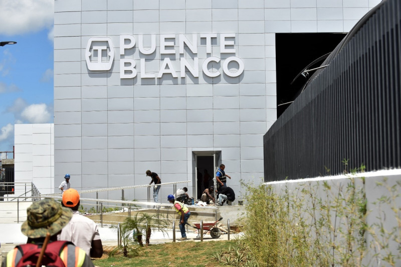 Obreros ultiman detalles en la colocación de barras metalicas en una de las entradas del teléferico.