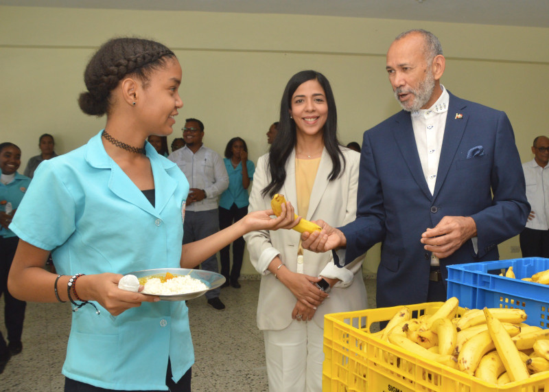 Alumna recibe guineo para complementar su almuerzo escolar