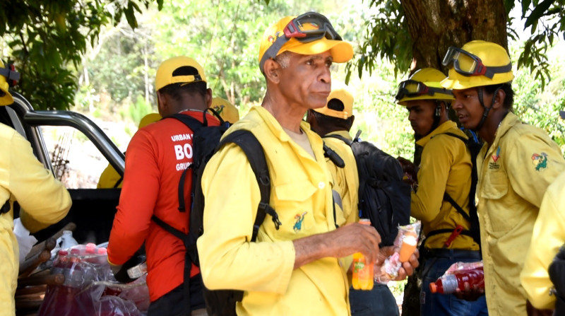 Uno de los integrantes de la Brigada Norte, de La Vega, come pan con jugo de naranja, junto a sus compañeros de batalla, minutos antes de combatir un fuego forestal.