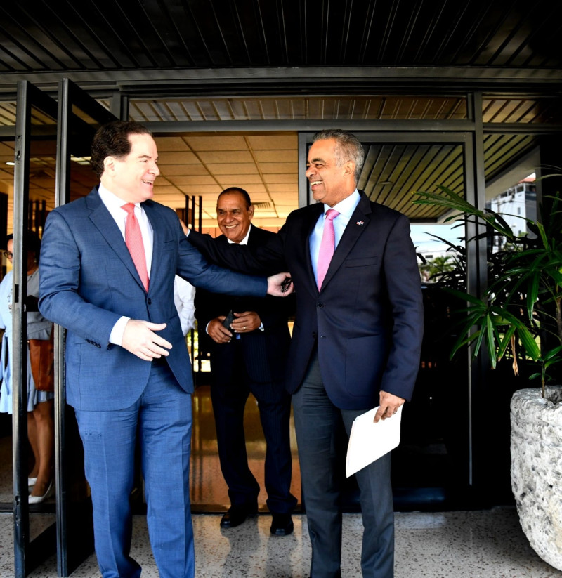 El ministro Joel Santos saluda a Manuel Corripio en la entrada del Listín. Detrás el director del periódico, Miguel Franjul.