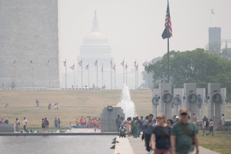 Los turistas caminan por el National Mall mientras el humo de los incendios forestales en Canadá provoca condiciones de niebla en Washington, DC, el 7 de junio de 2023.