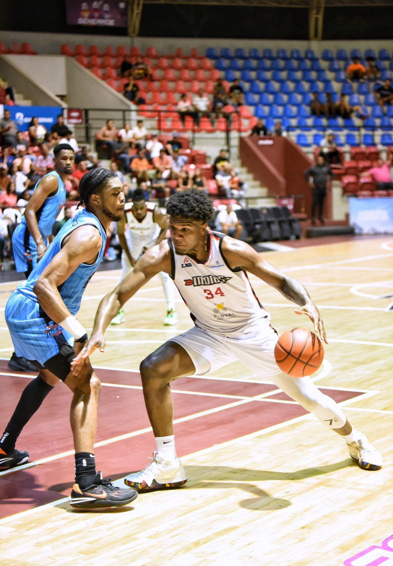 El joven jugador de los Indios, Luismal Ferreiras, en gestión ofensiva frente a la defensa del refuerzo Keith Jordan Jr. de los Titanes del Distrito.