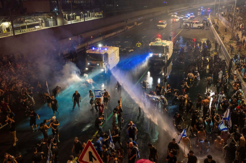 La policía antimotines intenta dispersar a manifestantes con un cañón hidrante durante una protesta contra el plan del gobierno de Benjamin Netanyahu de reformar el sistema judicial, antier.